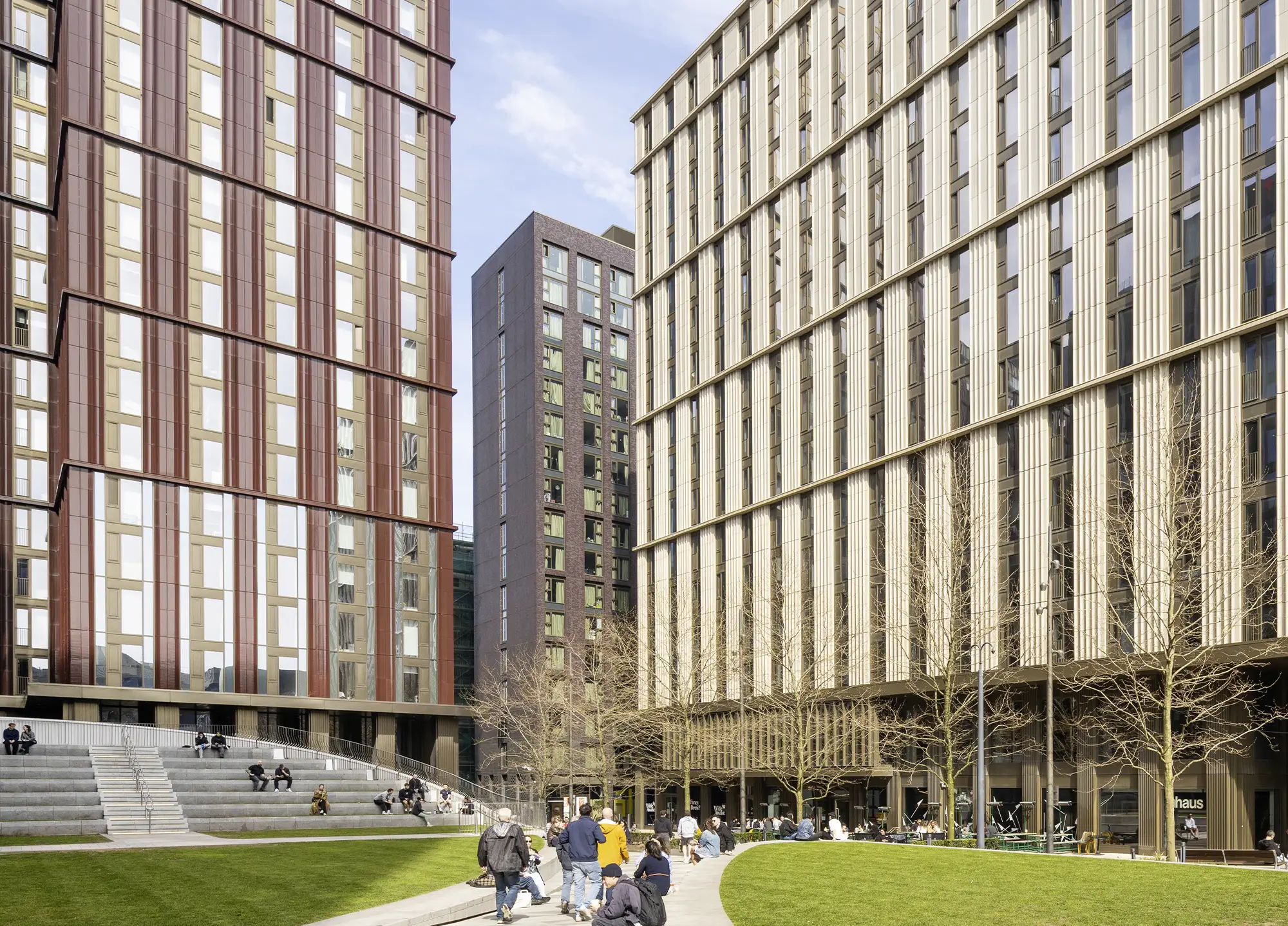 The Circle Square development in Manchester, with terracotta and gold-clad residential towers around a public lawn