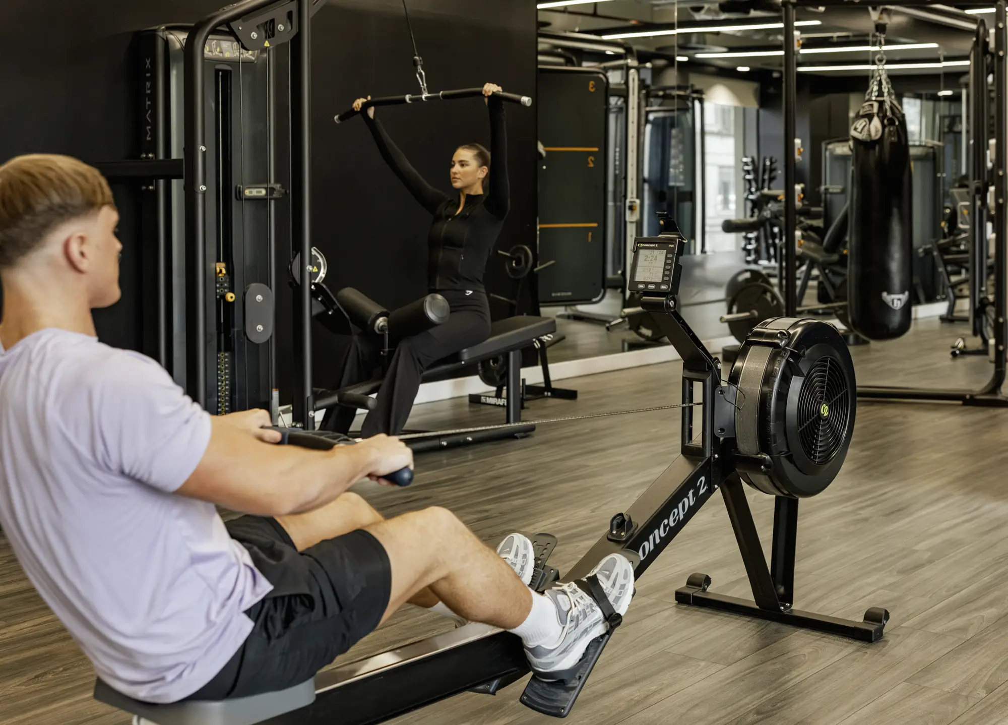 Residents working out in the on-site gym at Vita Living Circle Square North, with rowing machines, cable weight stations and a punchbag